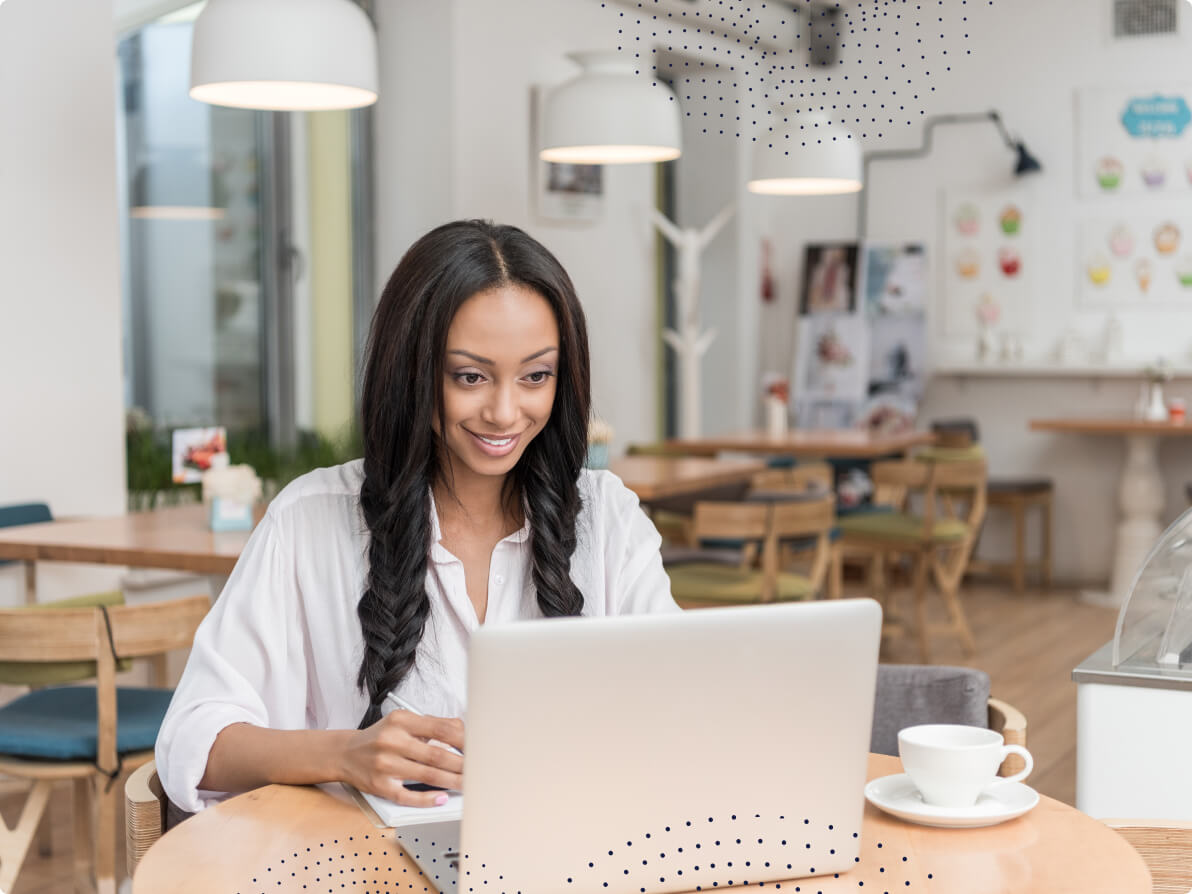 An Event organizer looking smiling at the laptop while she's working